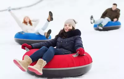 girl smiling while snow tubing