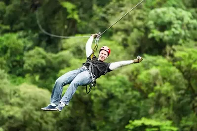 A man ziplining through the trees.