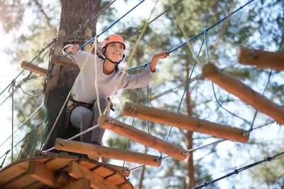 A woman enjoying a ropes course.